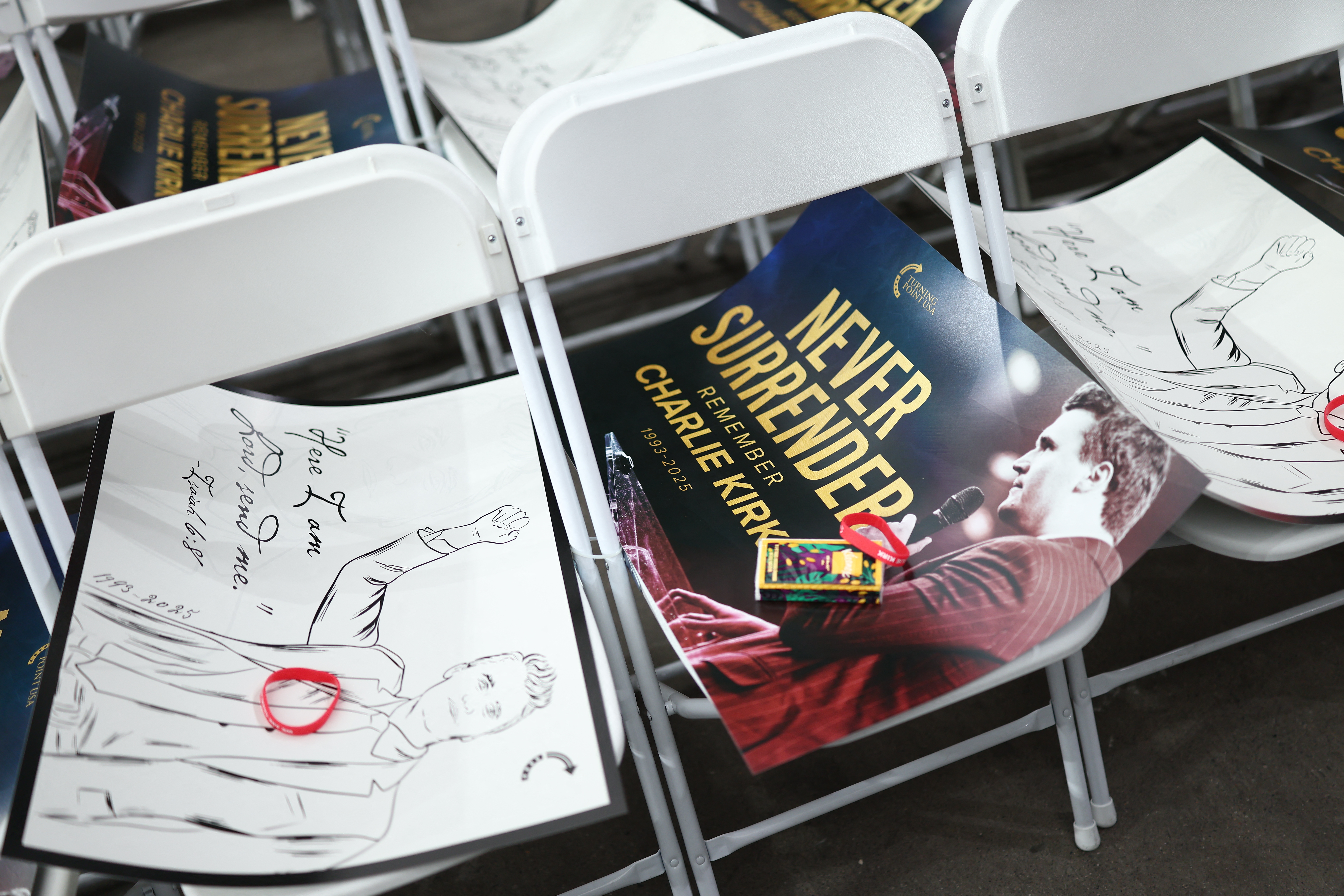 Signs are seen on chairs ahead of the public memorial service of conservative activist Charlie Kirk at the State Farm stadium in Glendale, Ariz. on Sept. 21.
